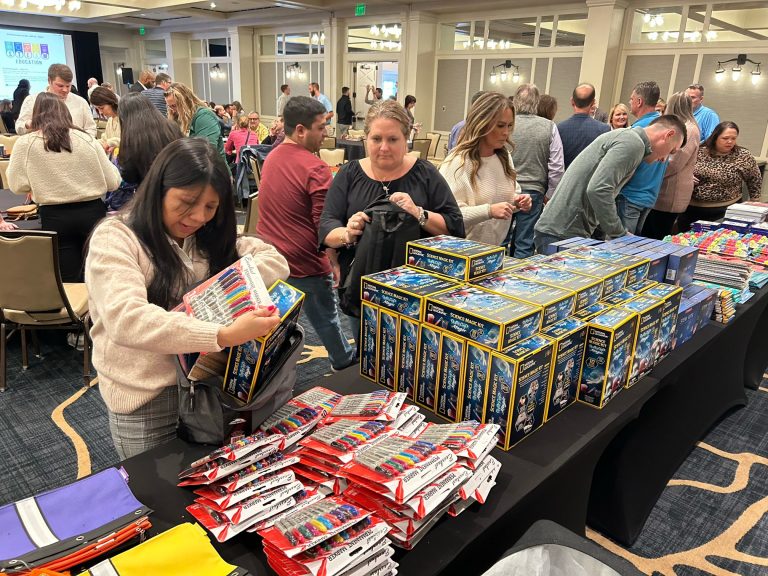 A group of people standing around a table full of books.