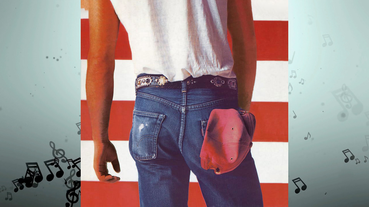 A man in a white shirt and blue jeans with a red hat in his pocket.