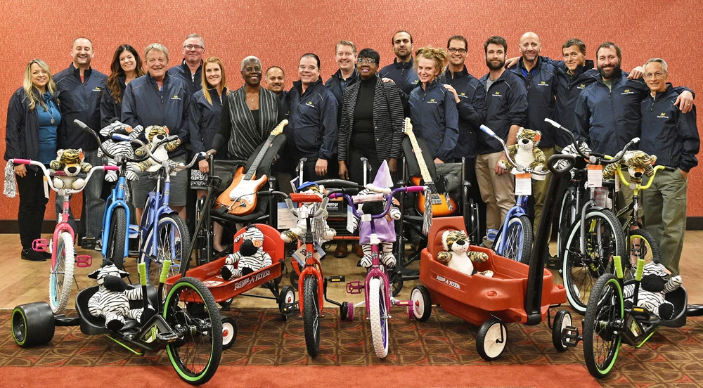 A group of people engaged in a corporate give back initiative, posing for a photo with bicycles.