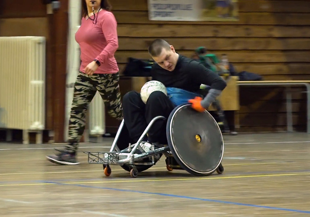 A man in a wheelchair is playing a game of soccer.