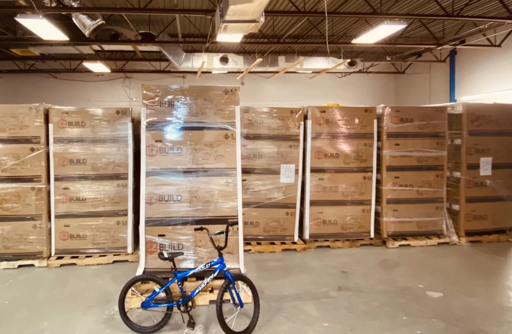 Live events return as a blue bicycle is parked in front of a stack of boxes.