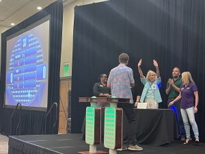 A group of people standing on a stage and waving their hands.