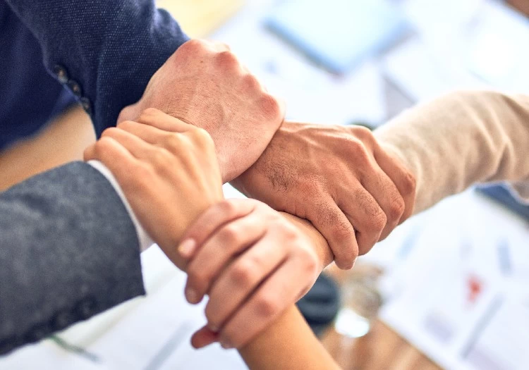 A team of business people putting their hands together for important team building exercises.