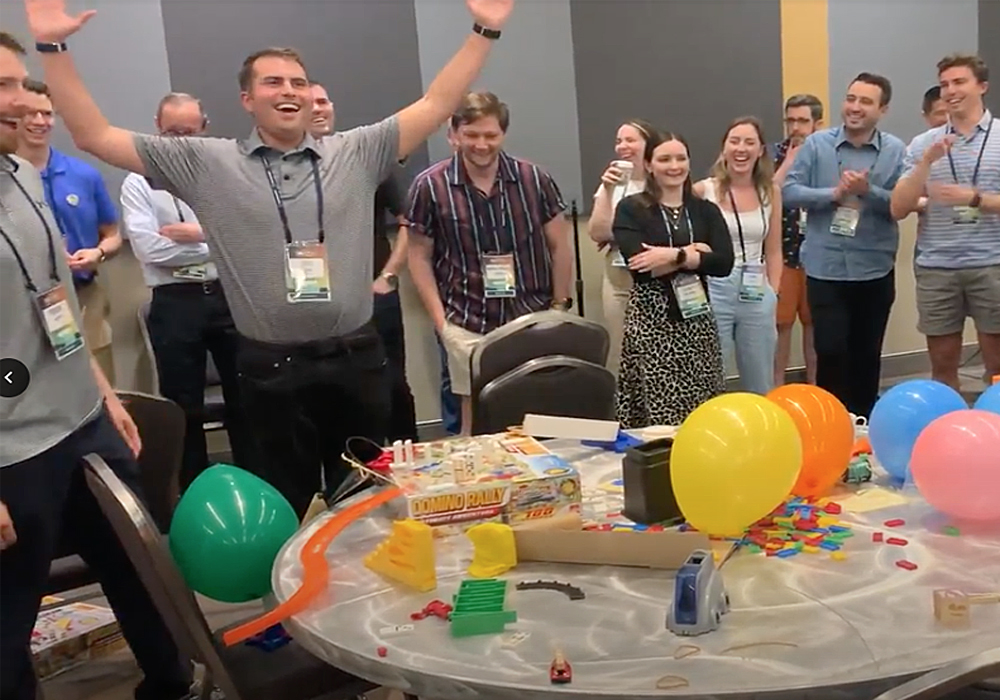 A group of people standing around a table with balloons.