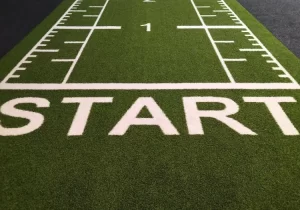 A football field with the word start written on it, promoting team building and employee orientation.