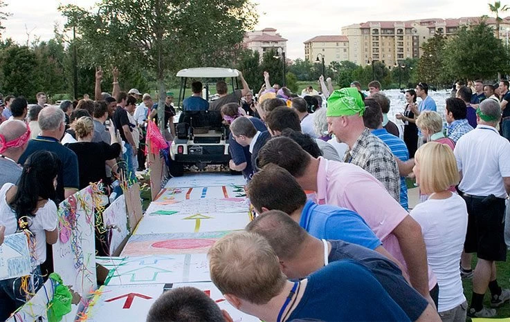 A crowd of people standing around a large table with signs.
