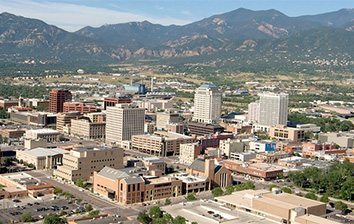 An aerial view of the city of colorado with mountains in the background.