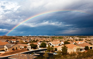 A rainbow is seen over a residential neighborhood.