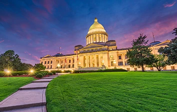 The state capitol building is lit up at dusk.