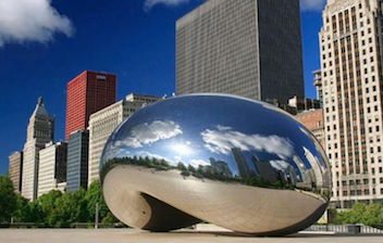 The chicago cloud gate is in the middle of a city.