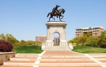 A statue of a man riding a horse in a park.