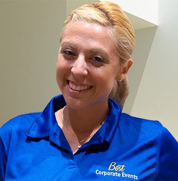 A woman in a blue polo shirt smiling.