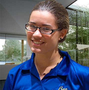 A young woman wearing glasses and a blue shirt.
