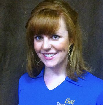 A woman in a blue shirt smiling at the camera.