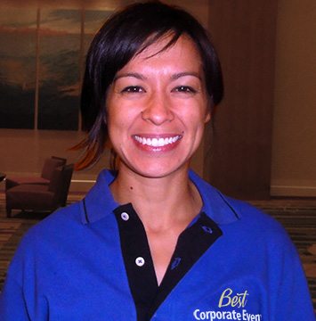 A woman in a blue shirt smiling for the camera.