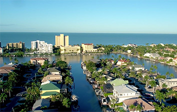 An aerial view of a neighborhood with houses and a body of water.