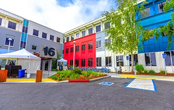 A brightly colored building with a parking lot.