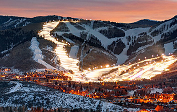 A ski slope lit up at dusk.