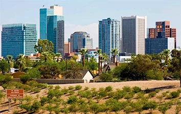 A city skyline with tall buildings and trees in the background, perfect for team building activities in Tempe, AZ.