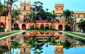 A corporate events venue with an ornate building, surrounded by a serene pond and shaded by tall palm trees in San Diego.