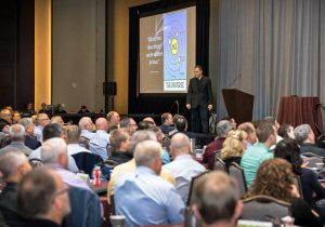 A man giving a presentation to a large group of people.