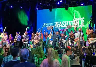 Best Corporate Events featuring a group of people standing on stage at a concert.