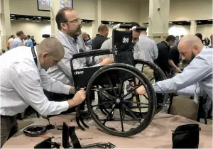 A group of men working on a wheelchair at the Best Corporate Events convention.
