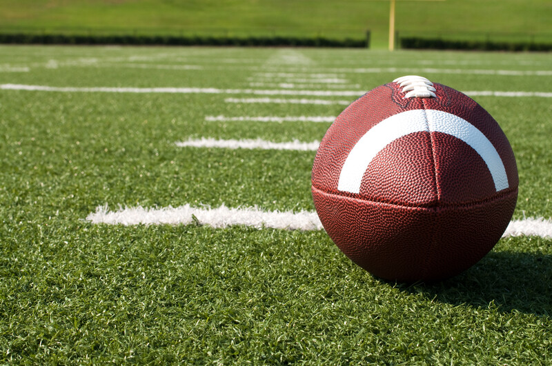 Discover valuable business lessons from the world of sports as you observe a football resting on a vibrant field.