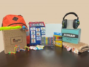 A table with a backpack, headphones, and other items.