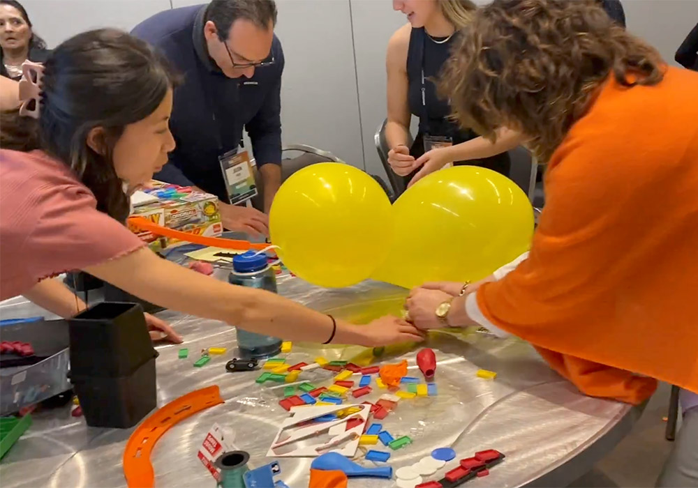 A group of people working on a table with balloons.