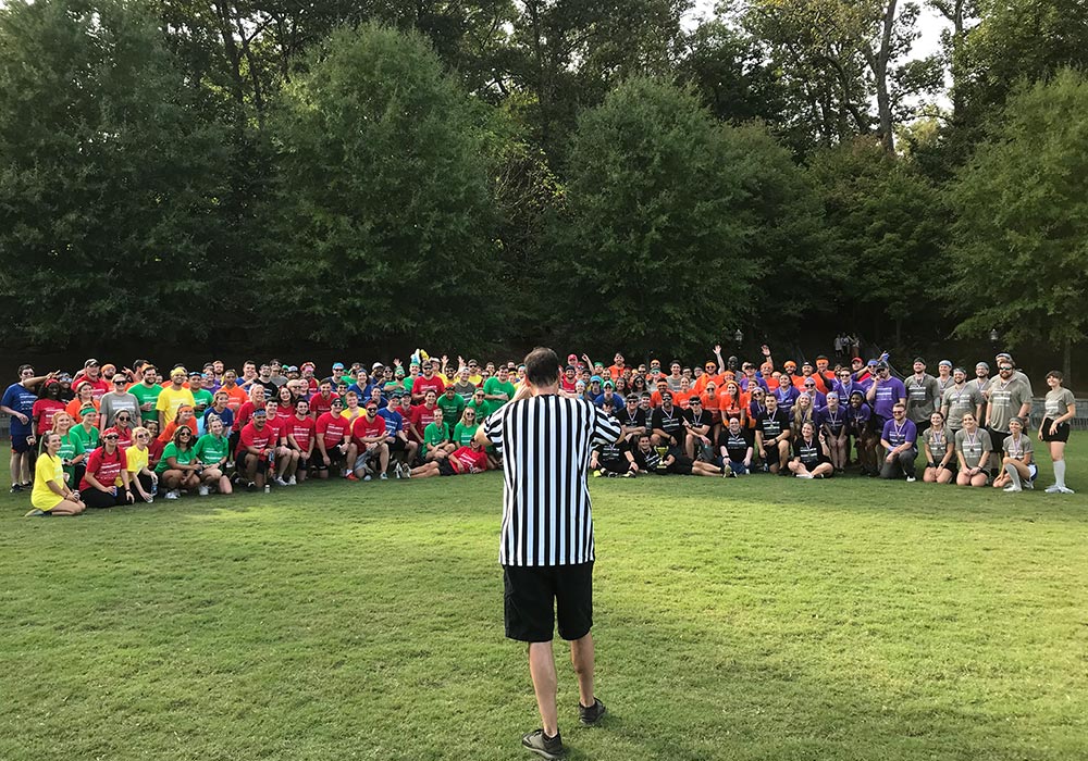 A group of people standing in a field with a referee.