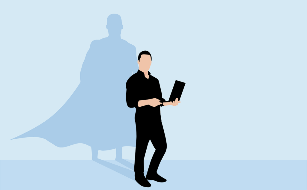 A person stands holding a laptop, their shadow behind them in the shape of a superhero wearing a cape—rising above the challenges of a bad boss.