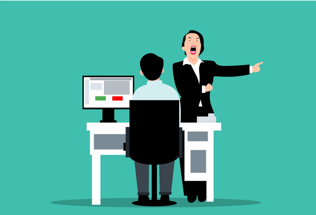 A person sits at a desk with a computer while another person, standing and pointing away, appears to be angrily instructing or dismissing them.