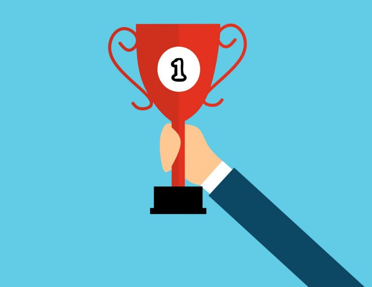 Illustration of a hand in a suit holding up a red trophy with a &ldquo;1&rdquo; on it against a blue background, symbolizing recognition at the best corporate team building events.
